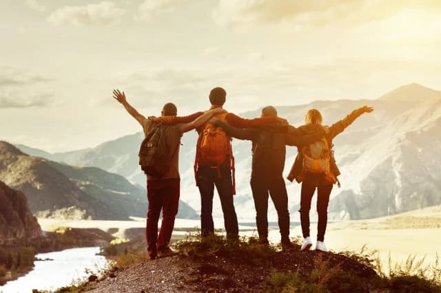 Wandergruppe auf Gipfel mit Bergpanorama